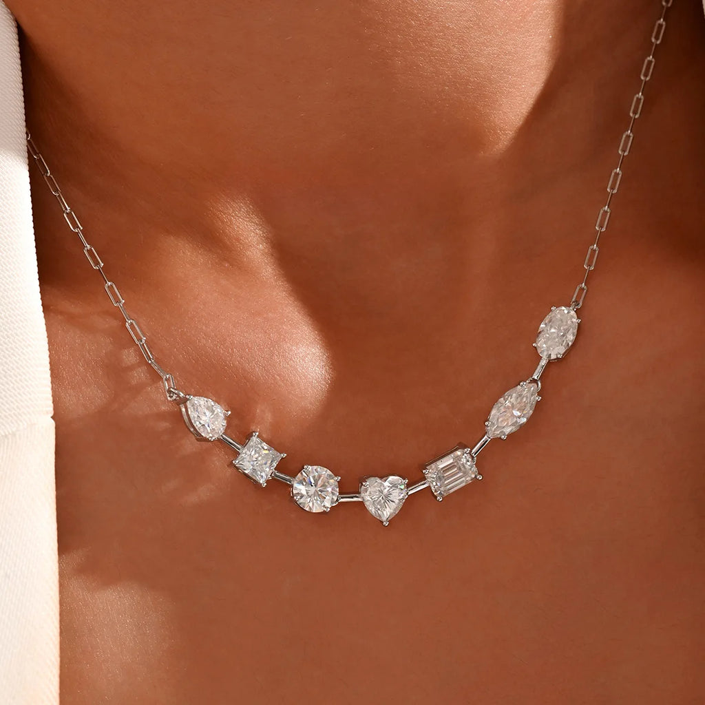 Silver necklace with various diamond shapes worn by a person against a neutral background