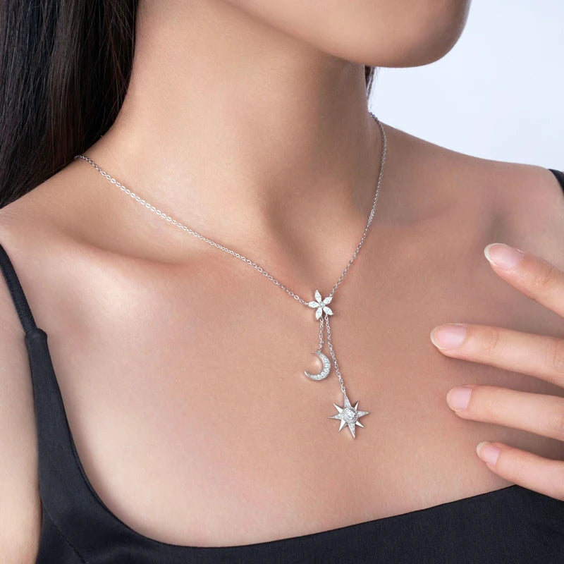 Necklace with star, moon, and sun moissanite diamond pendant worn by a person