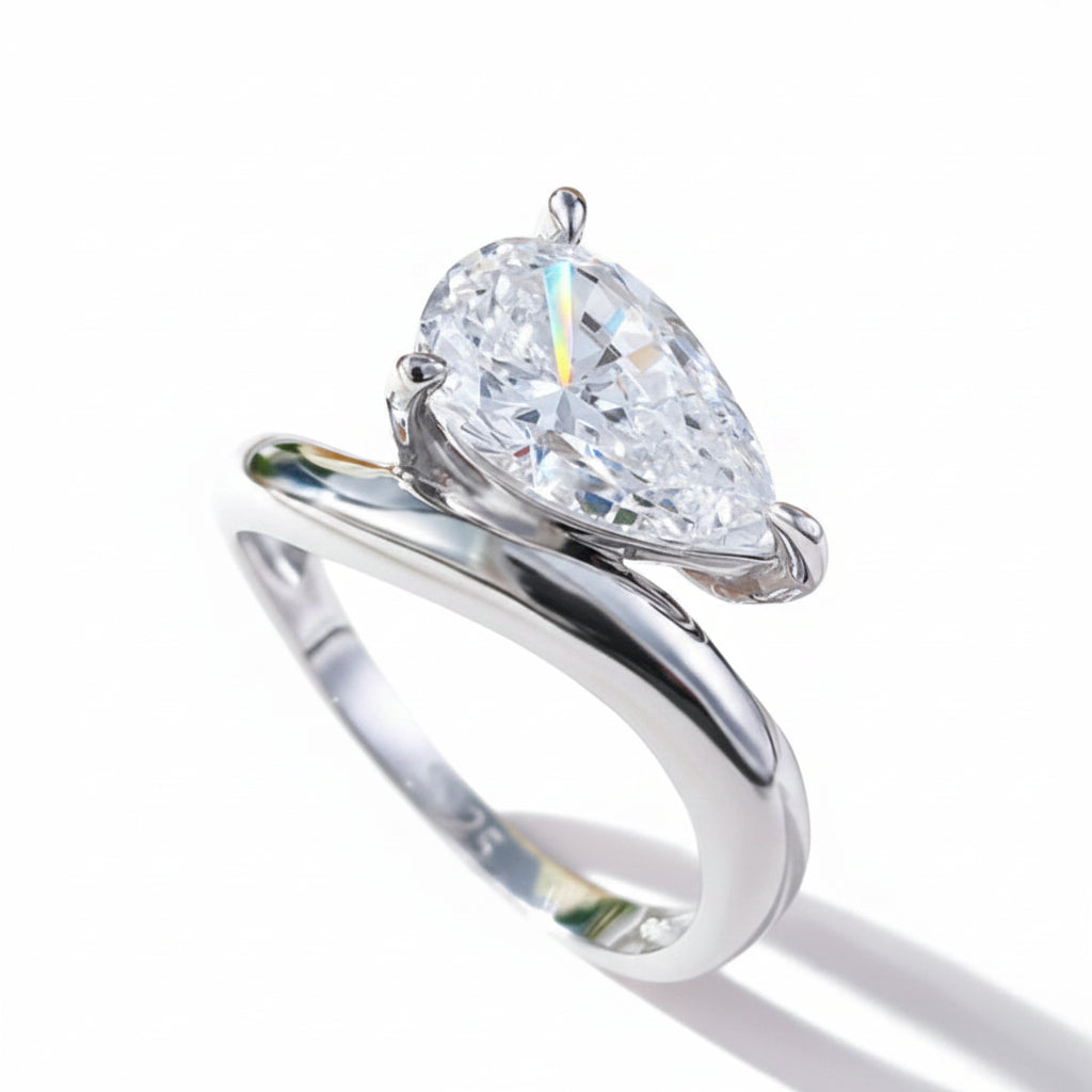 Silver ring with a pear-shaped moissanite  on a white background.