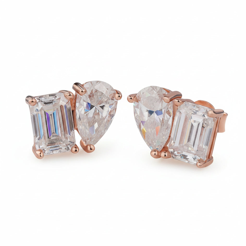 Pair of moissanite diamond earrings with rose gold settings on a white surface.