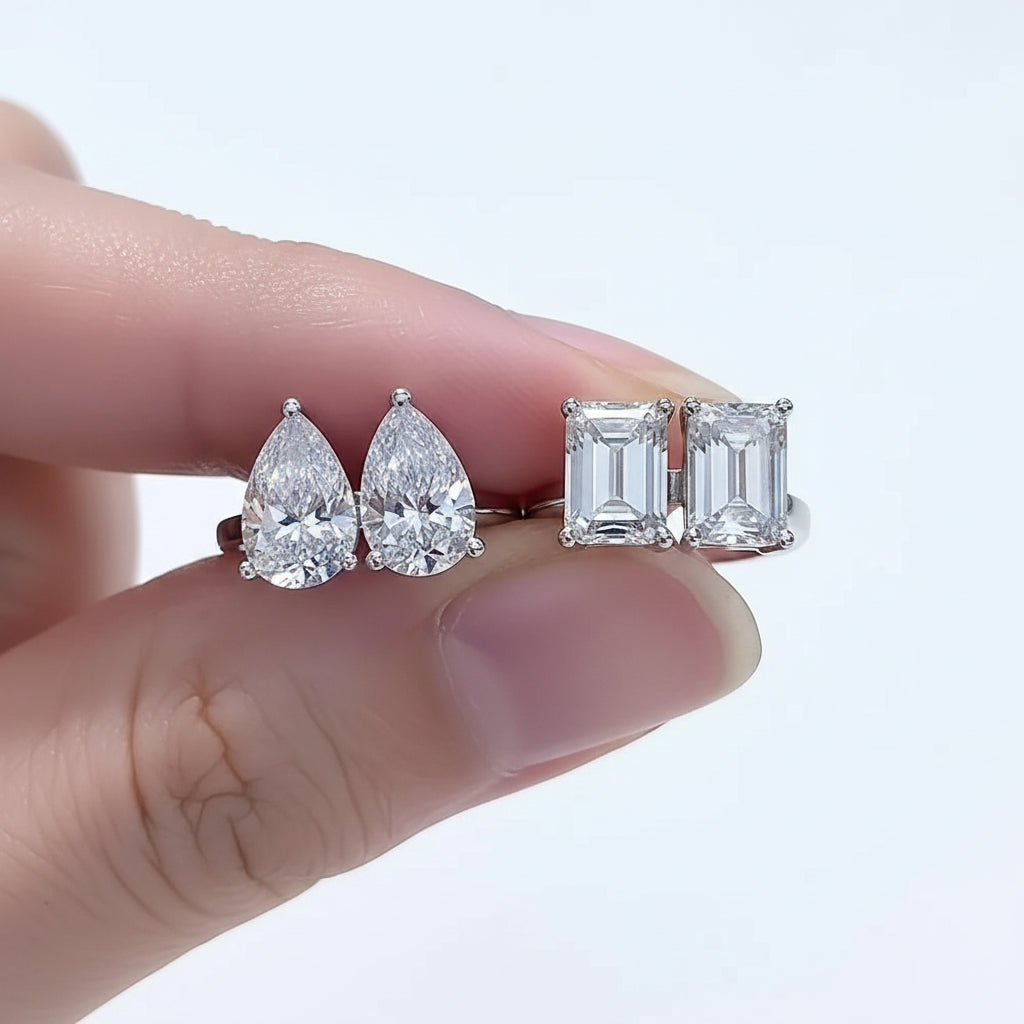 Moissanite diamond earrings on a finger with a white background