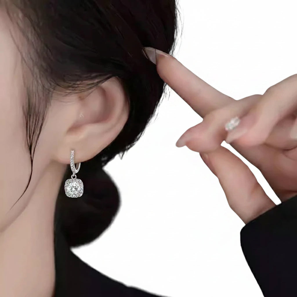 Close-up of a person wearing a silver earring with a white background