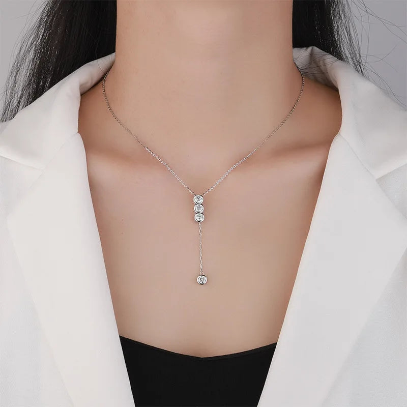 Necklace with four moissanite pendants on a mannequin wearing a white blazer.