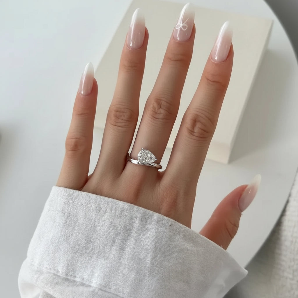 Hand wearing a moissanite ring with a white background