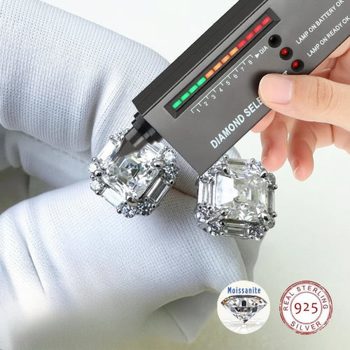 Diamond selector tool being used on two large diamonds held by a person wearing gloves.